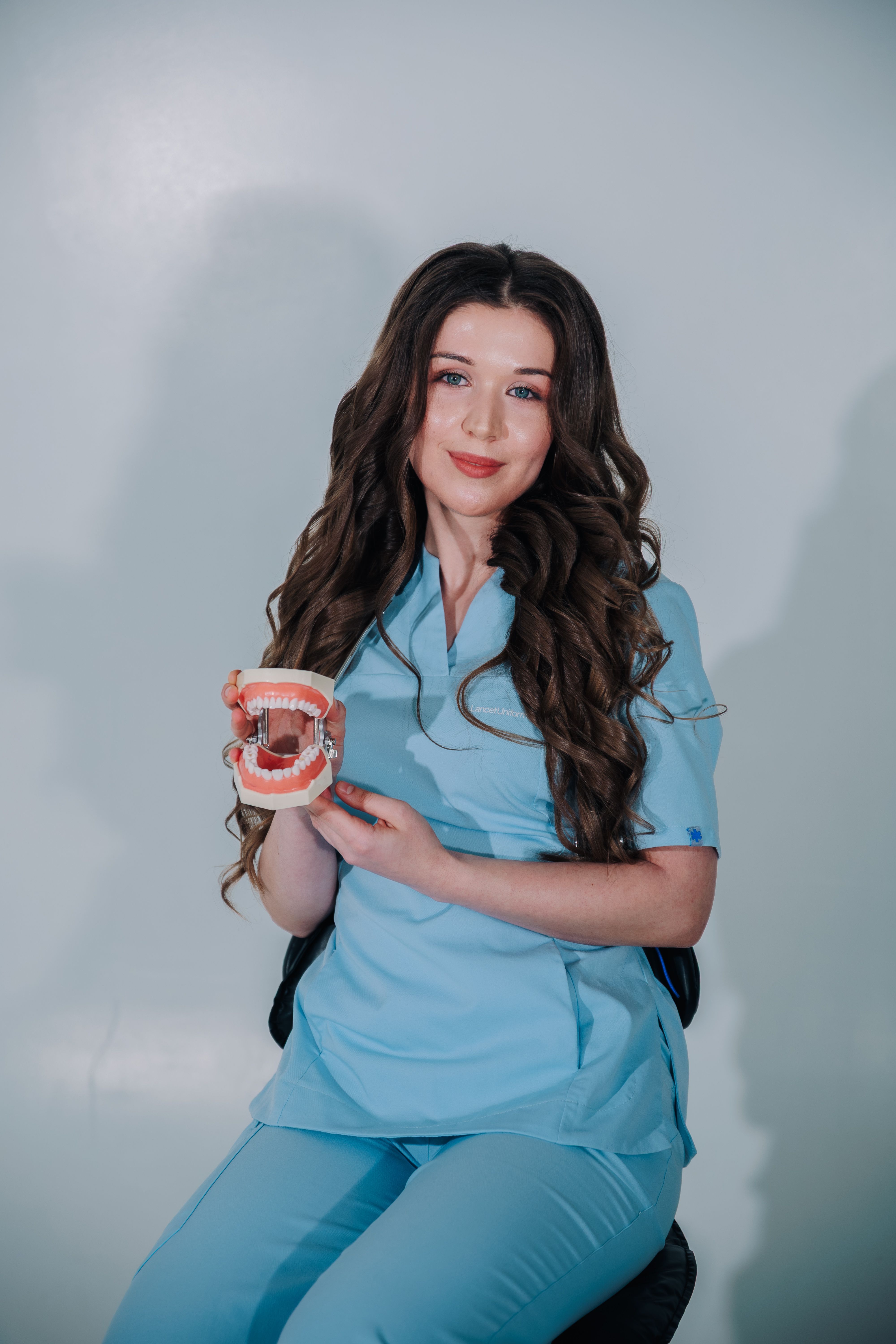 Portrait of Dr. Emma Lin holding a dental model in the clinic
