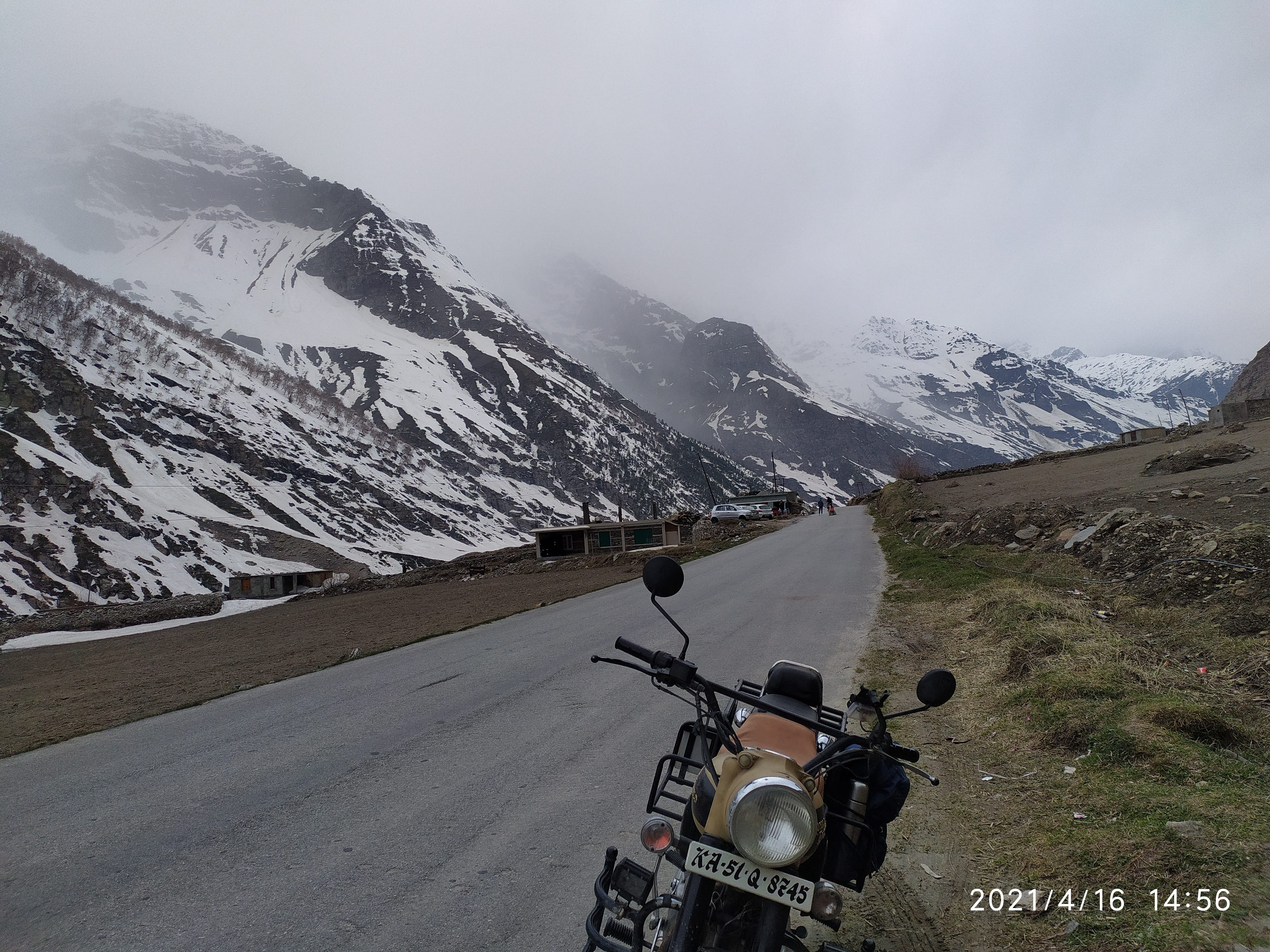 Riders resting beside motorcycles high in the mountains