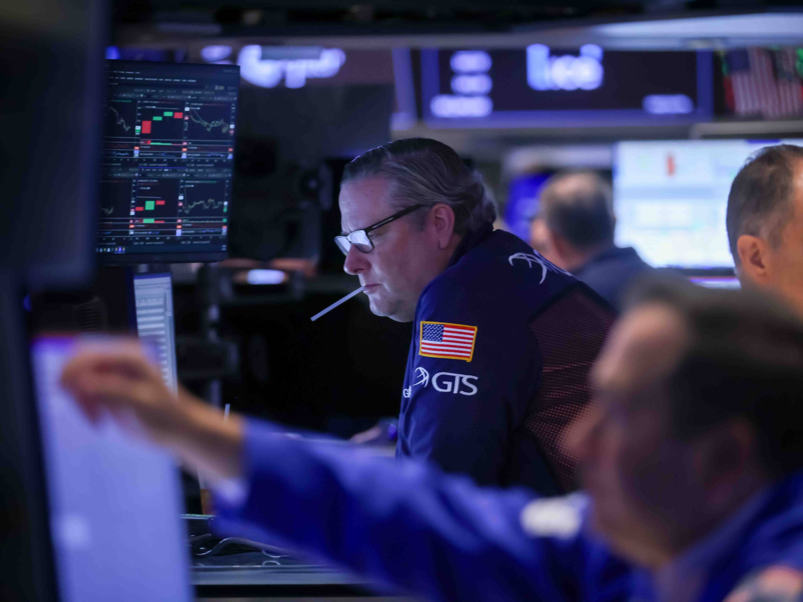 A confident trader posing before market screens, the glossy image fake gurus rent to look real