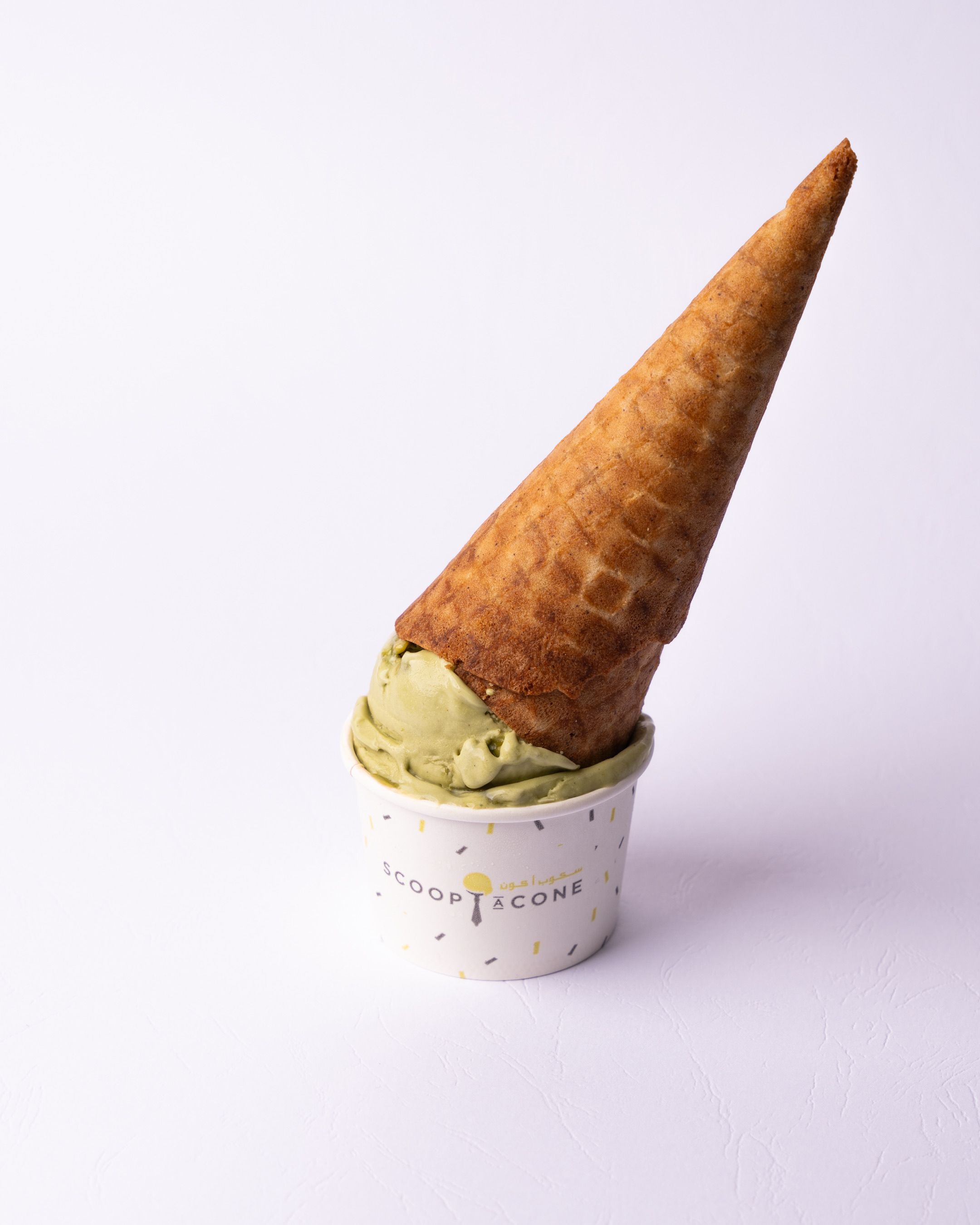 A scoop of pistacchio gelato served in a small cup