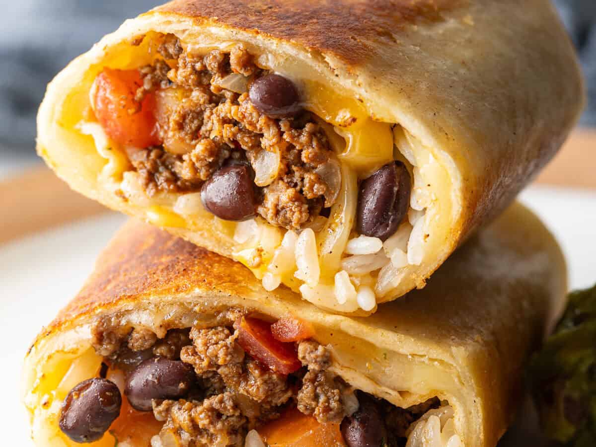 Two stacked burritos filled with ground beef, black beans, and rice