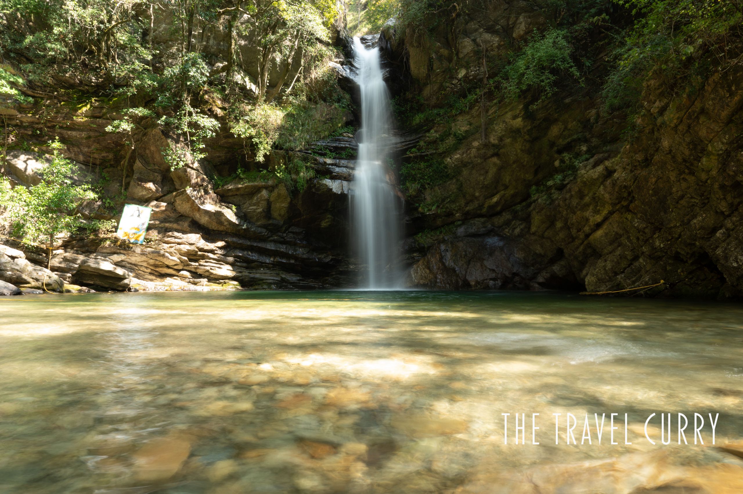 Monsoon waterfall falling through green forest in Uttarakhand, India
