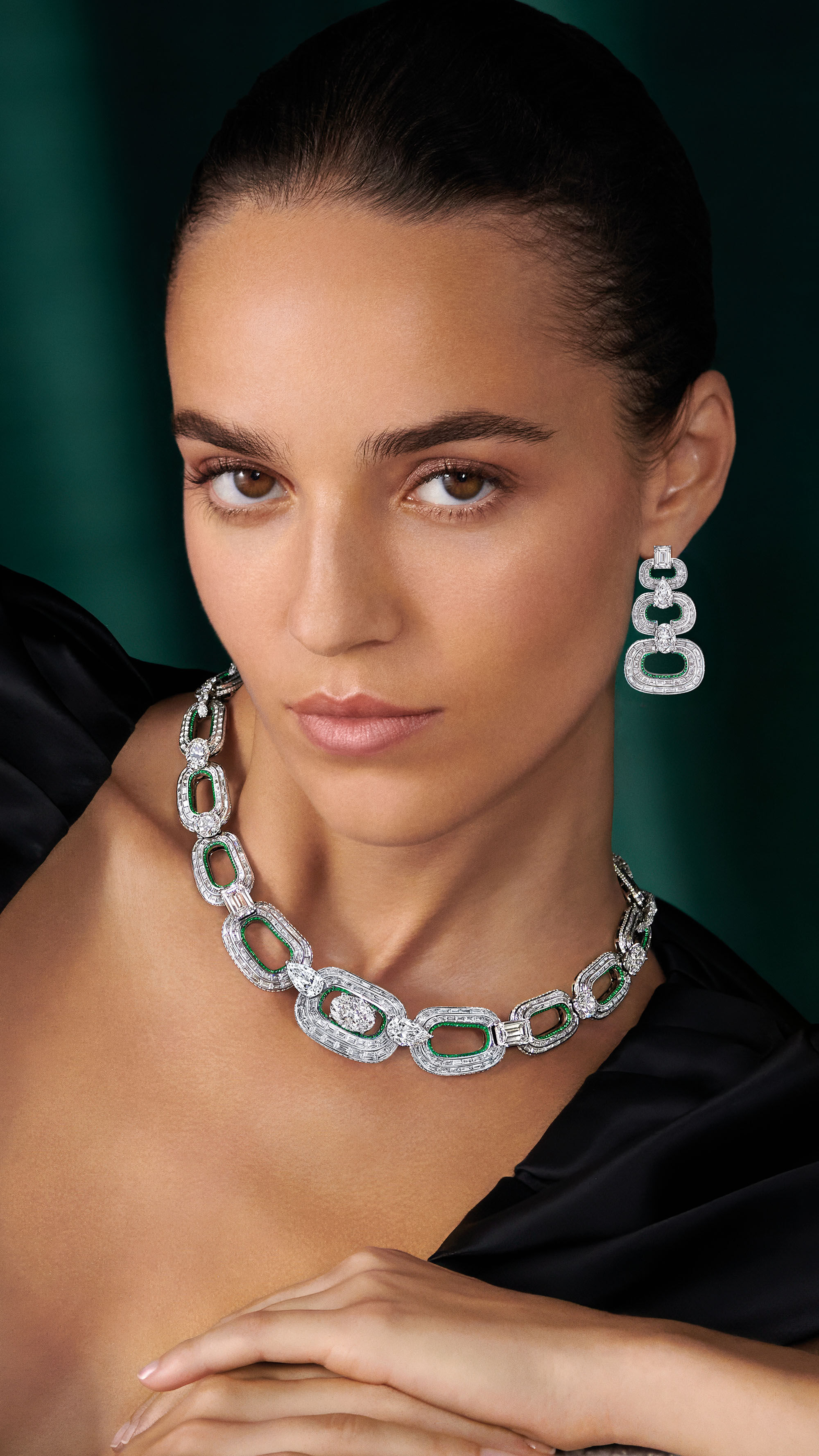 Model wearing luxurious diamond and emerald necklace