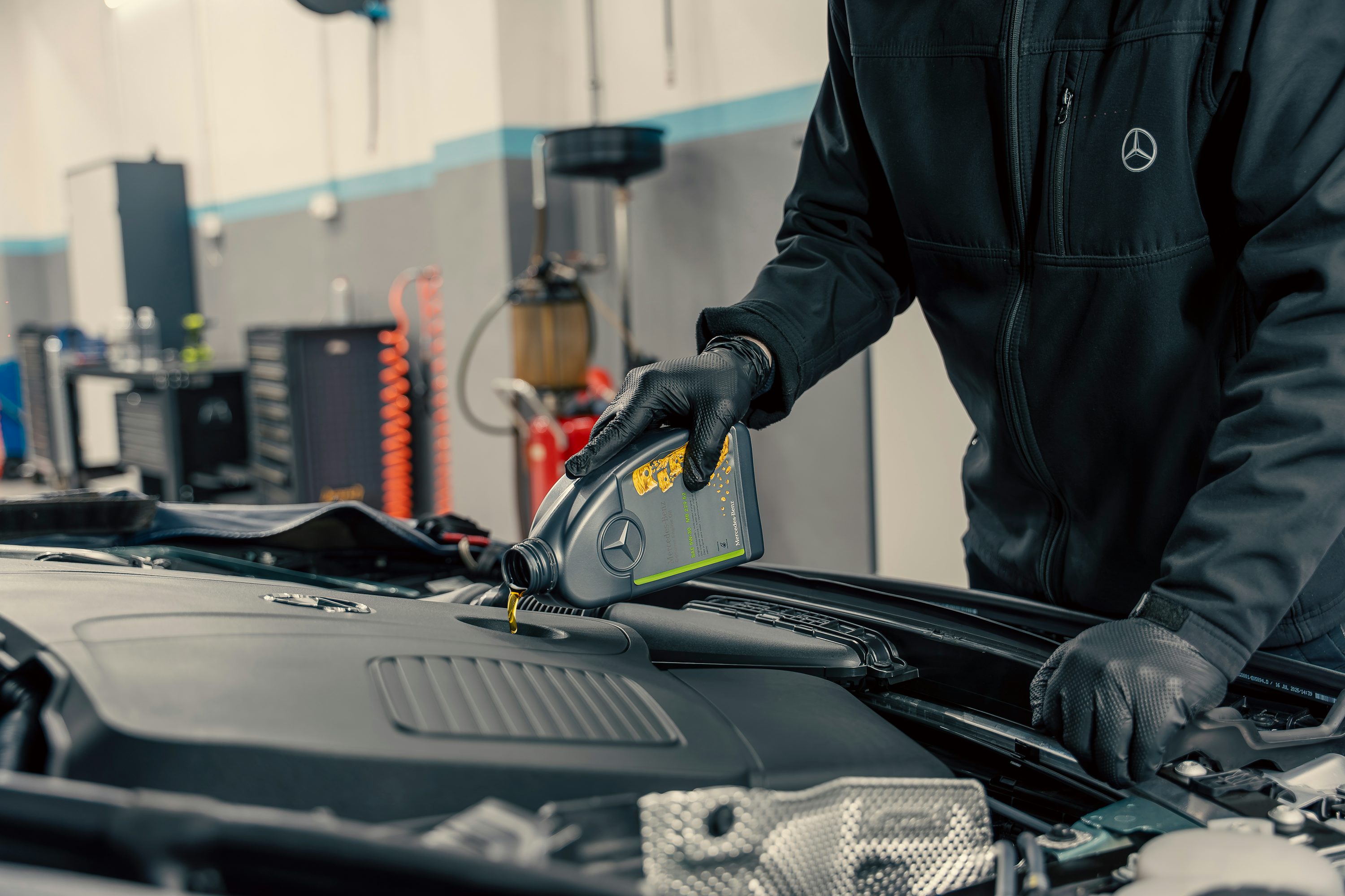Professional mechanic working under the car hood inspecting the engine bay