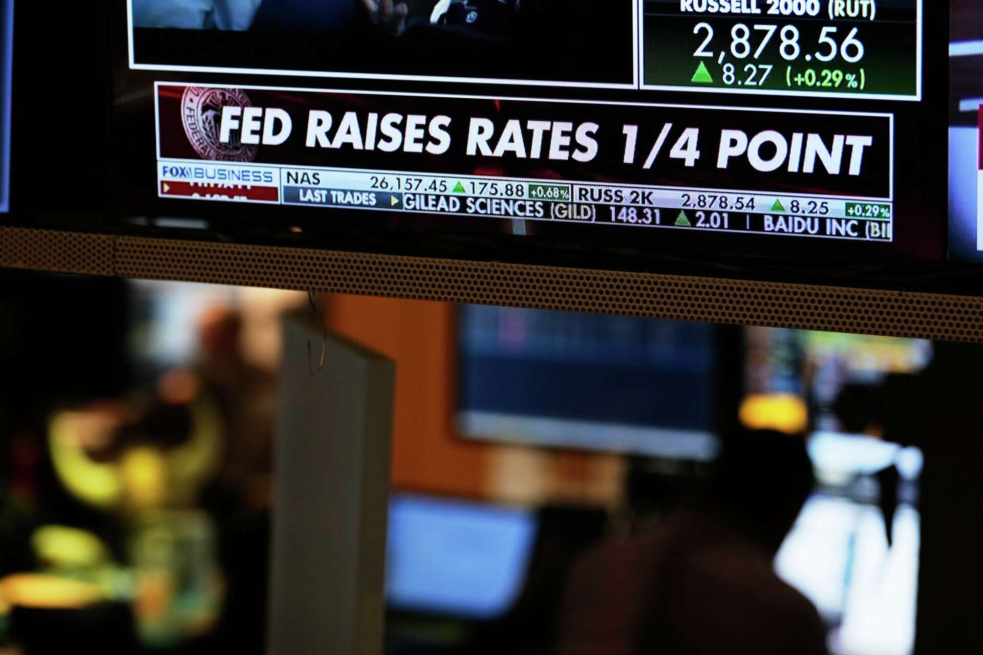 A ticker screen announcing a Fed rate decision, the kind of trigger that algorithms react to instantly
