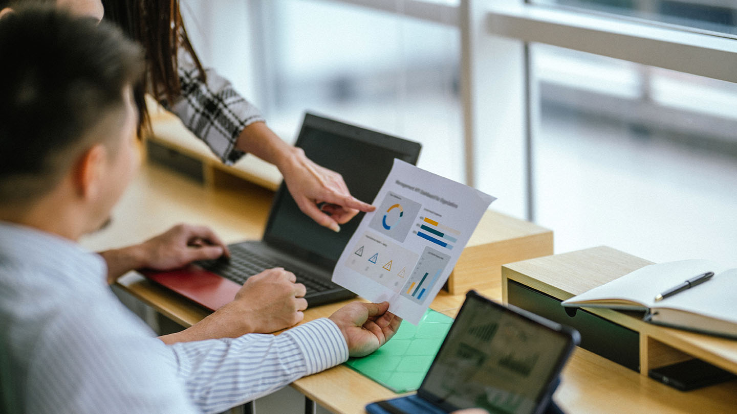 A financial advisor reviewing a plan with clients across a desk, the human service machines cannot copy