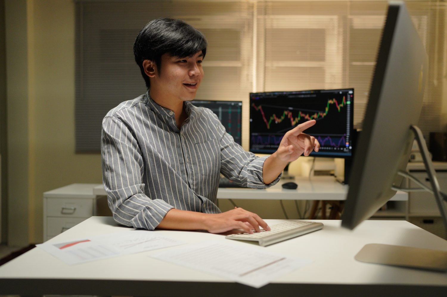 An analyst pointing at live market data while predictive analytics software scores the next move