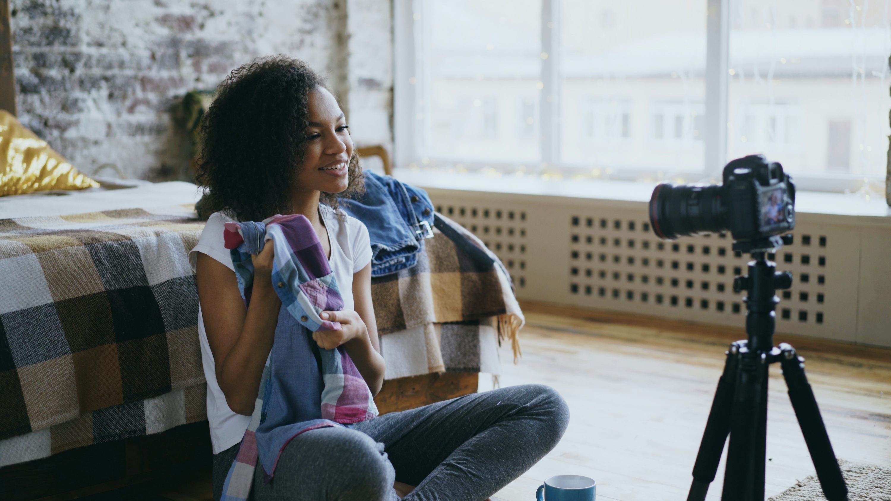 A vlogger recording a video at home with a camera on a tripod, the human warmth AI avatars still chase