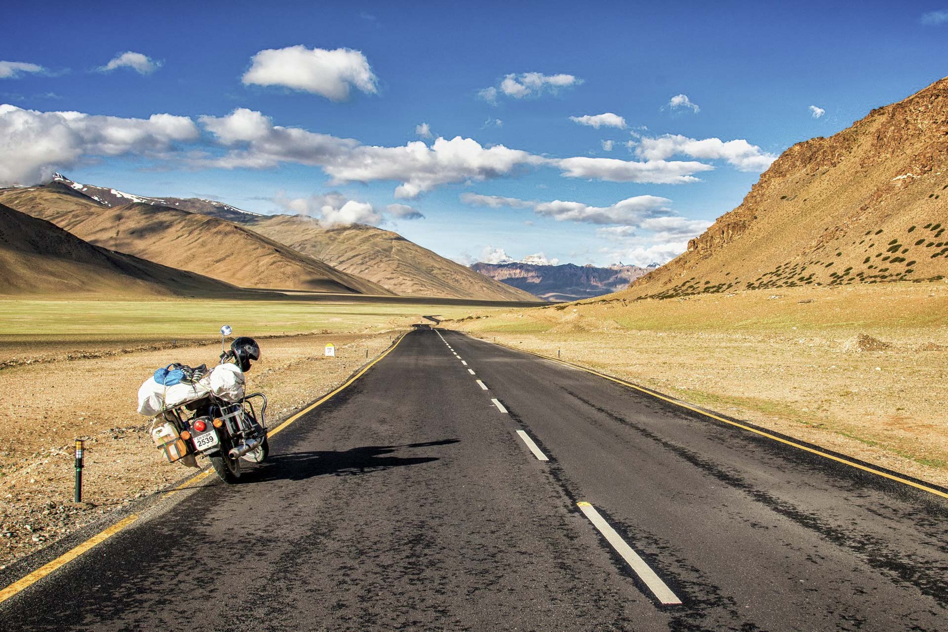 Motorcycle parked on a mountain road with valley view