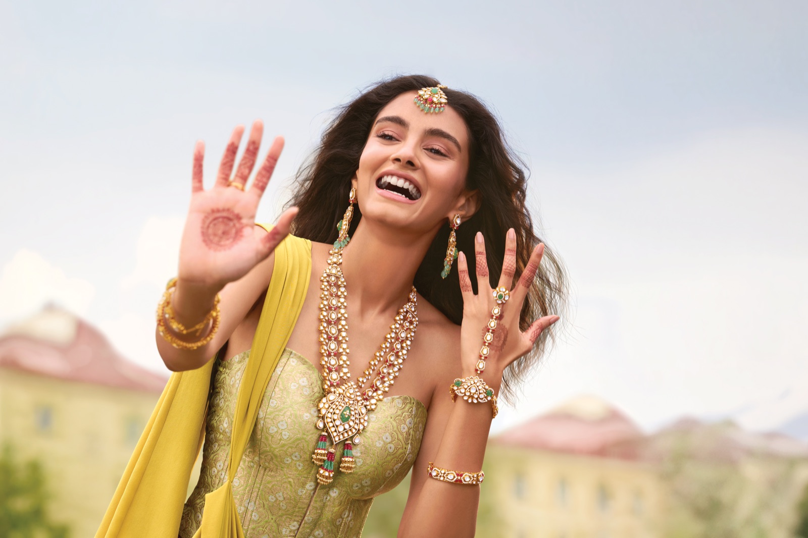 Woman with henna hands wearing elaborate gold jewellery