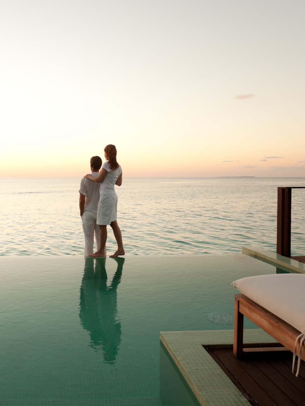 Couple enjoying the infinity pool at dusk