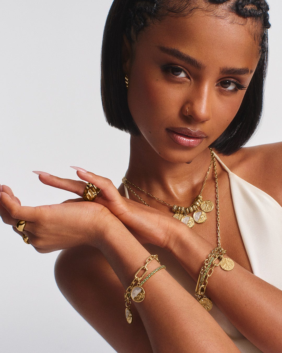 Editorial portrait of a model wearing layered gold necklaces and bracelets