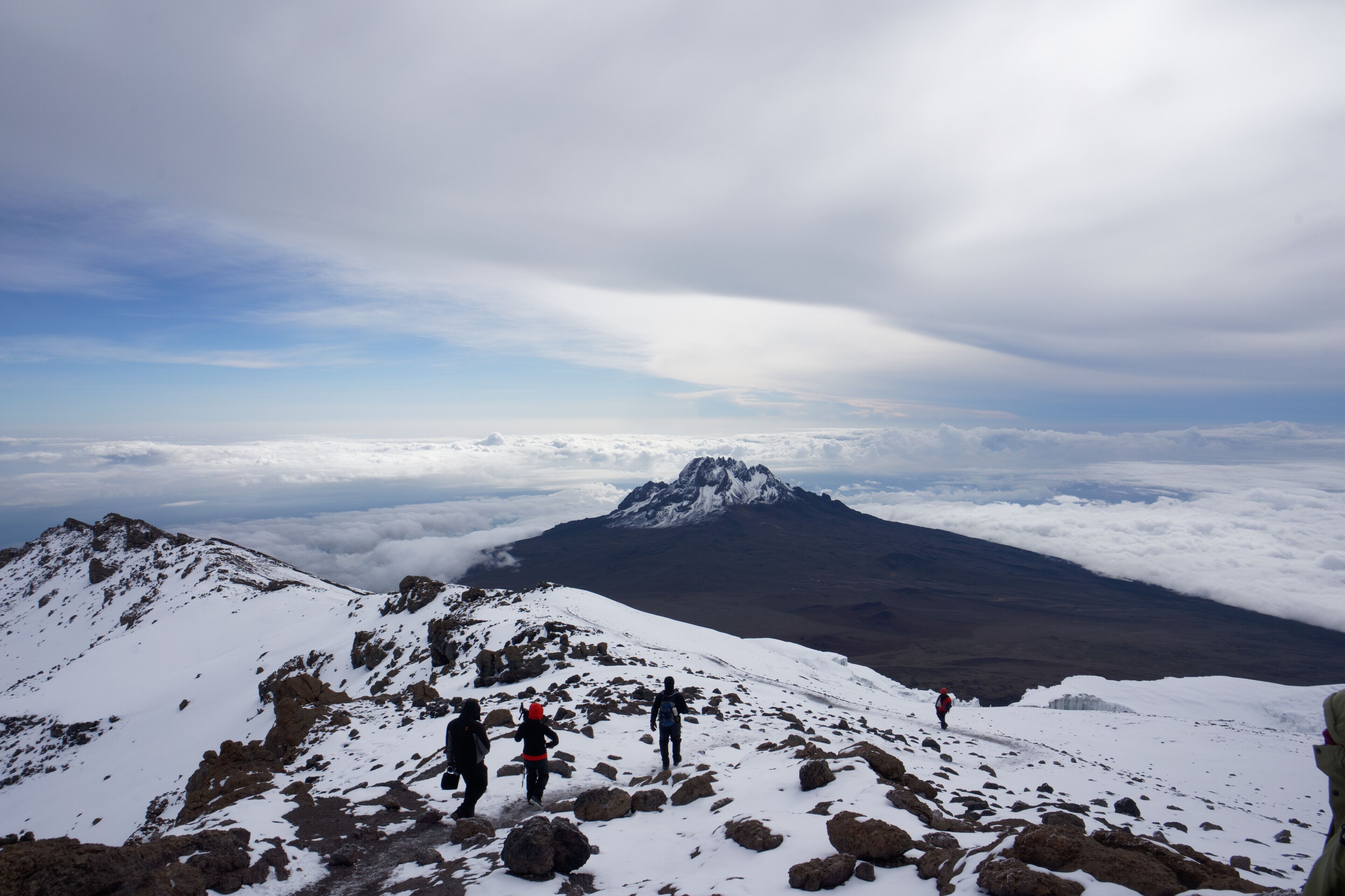 Trekkers on the summit snowfield with Mawenzi behind