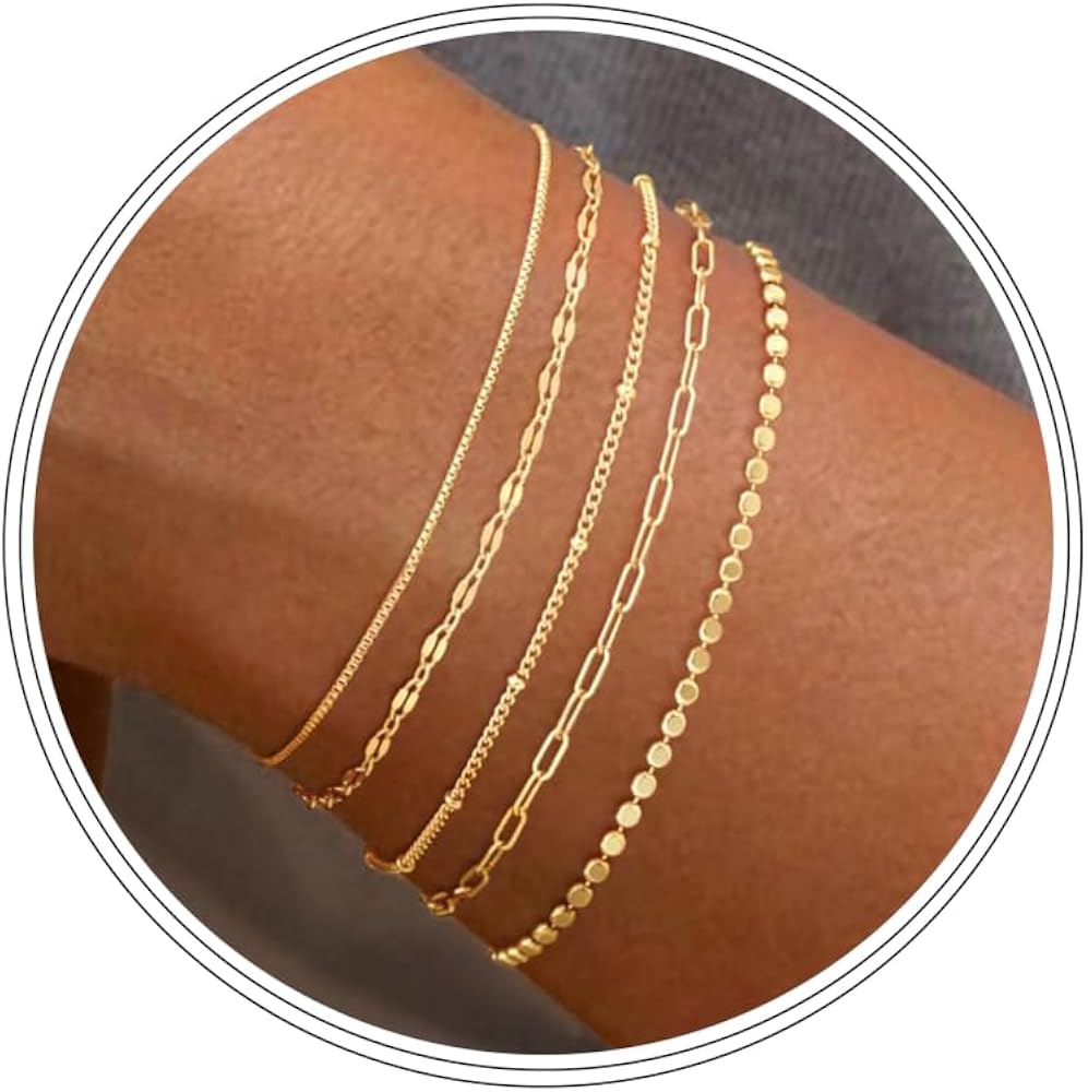 Stack of five delicate gold chain bracelets in mixed profiles on a wrist
