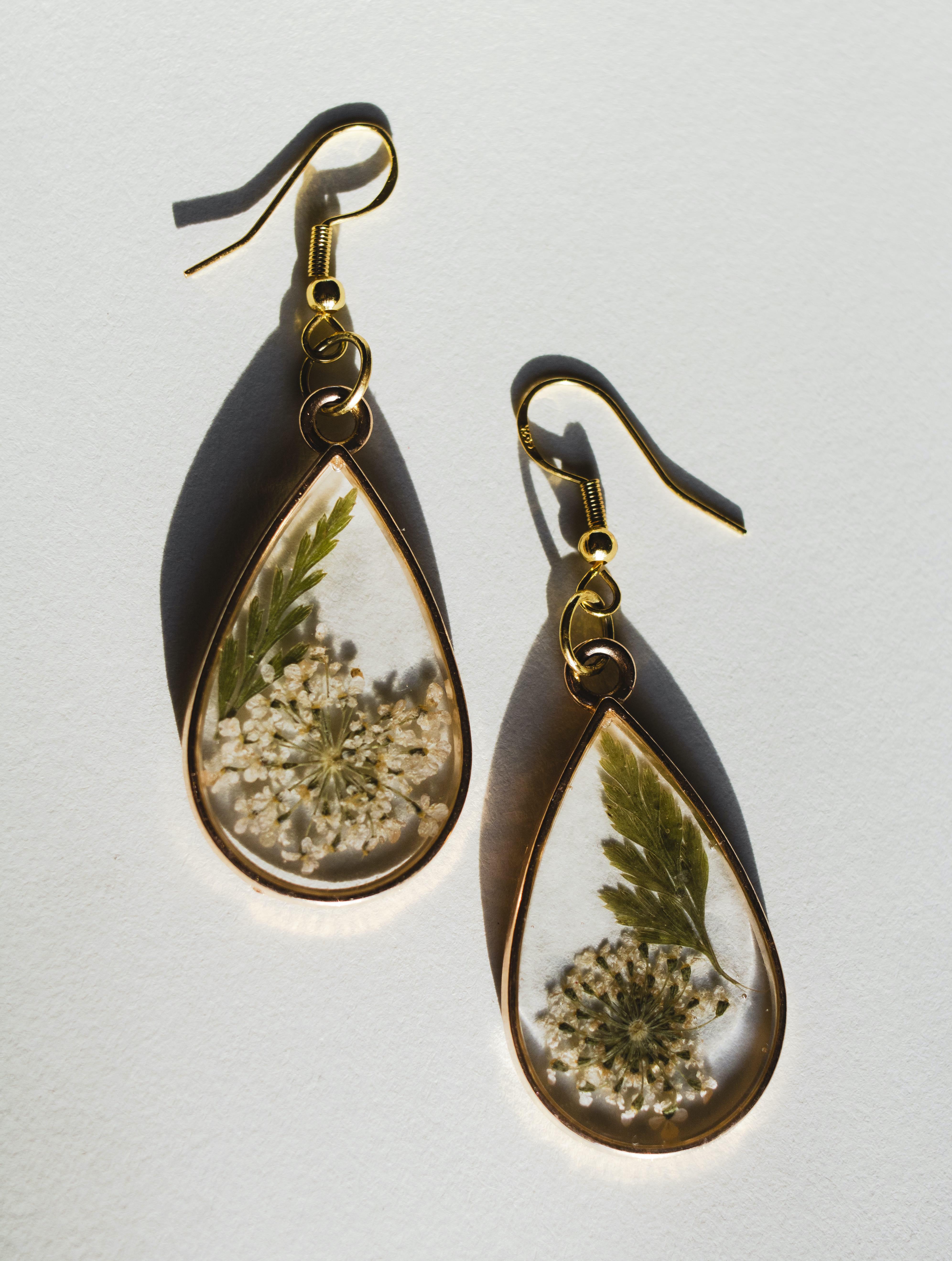 Iris teardrop gold earrings with pressed white flowers and green leaves