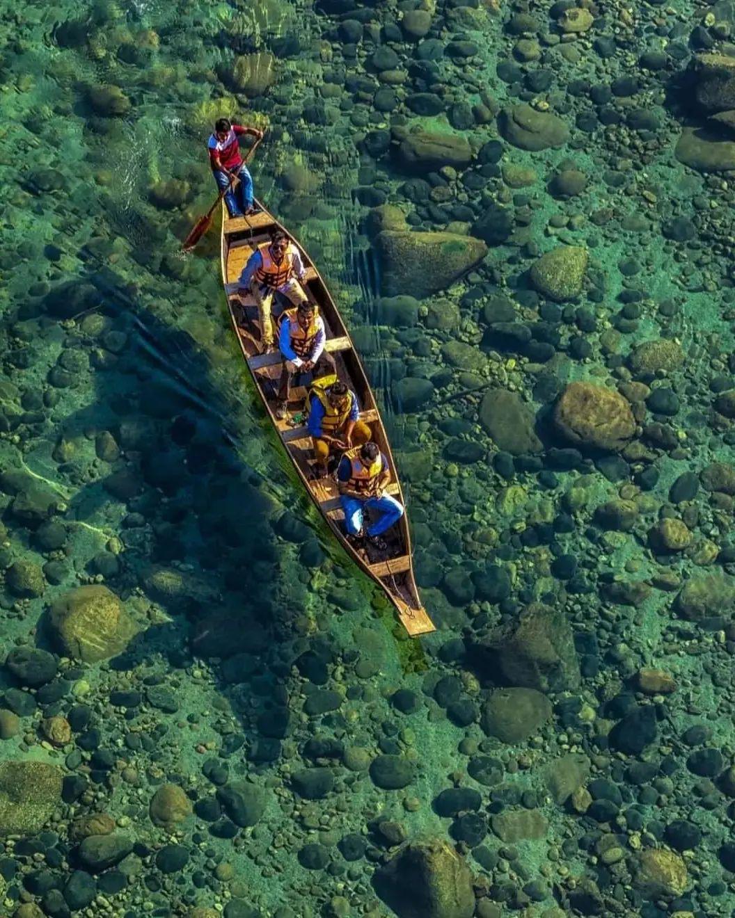 A canoe gliding over the crystal-clear Umngot river